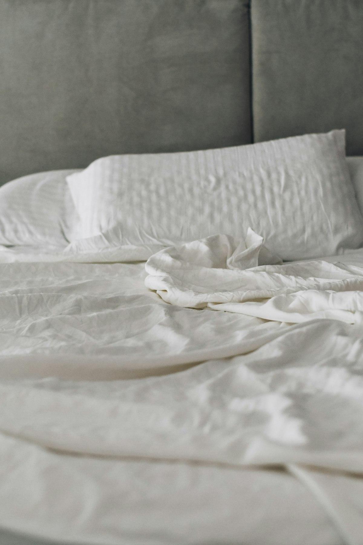 Neatly made bed with crisp white linens and pillows