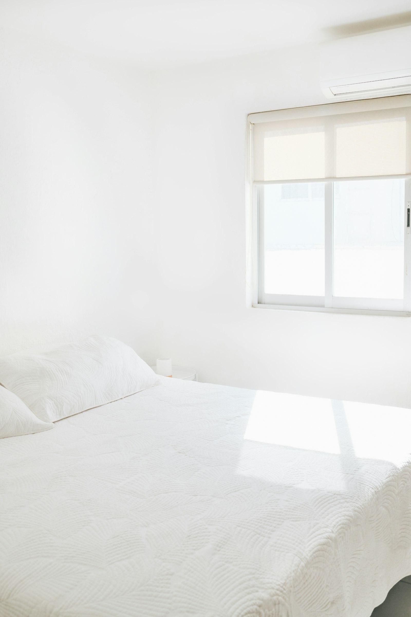 A bright white bedroom with soft morning light